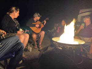 Jamie, Suzie and Paul enjoy Kyle playing the guitar around the campfire