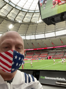 Photo of Brad sitting field side at BC Place at a rugby sevens match
